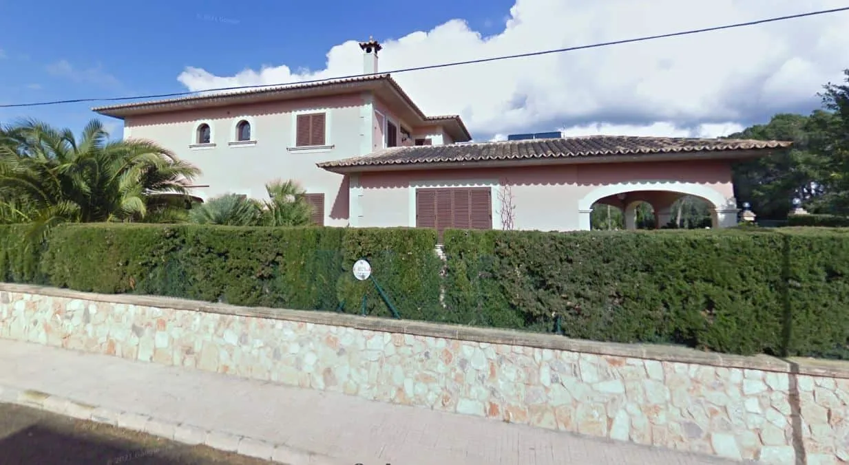 Fachada de la vivienda Xiela en Bunyola, Mallorca, con muro de piedra y setos en la calle