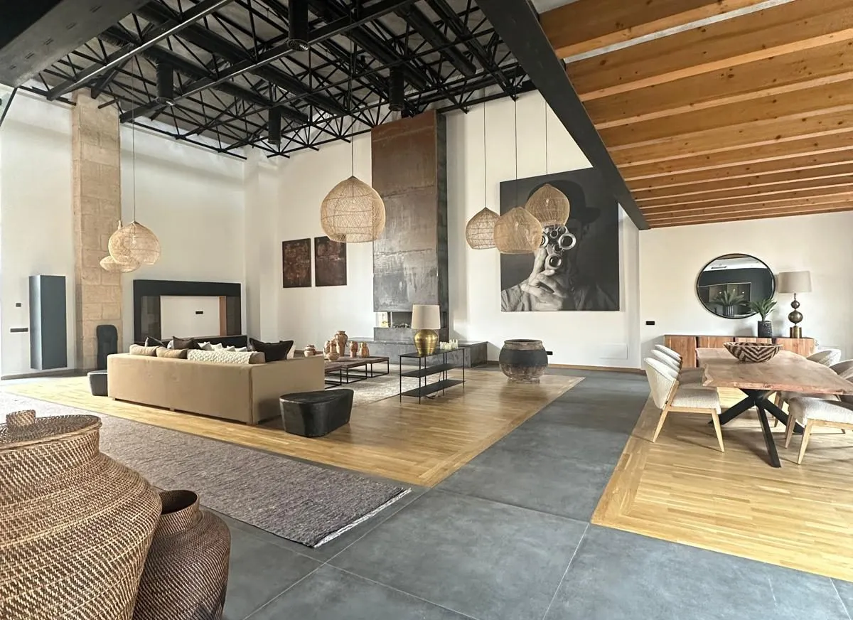 Salón a doble altura de la vivienda Cotoner en Santa Catalina, con estructura metálica y vigas de madera