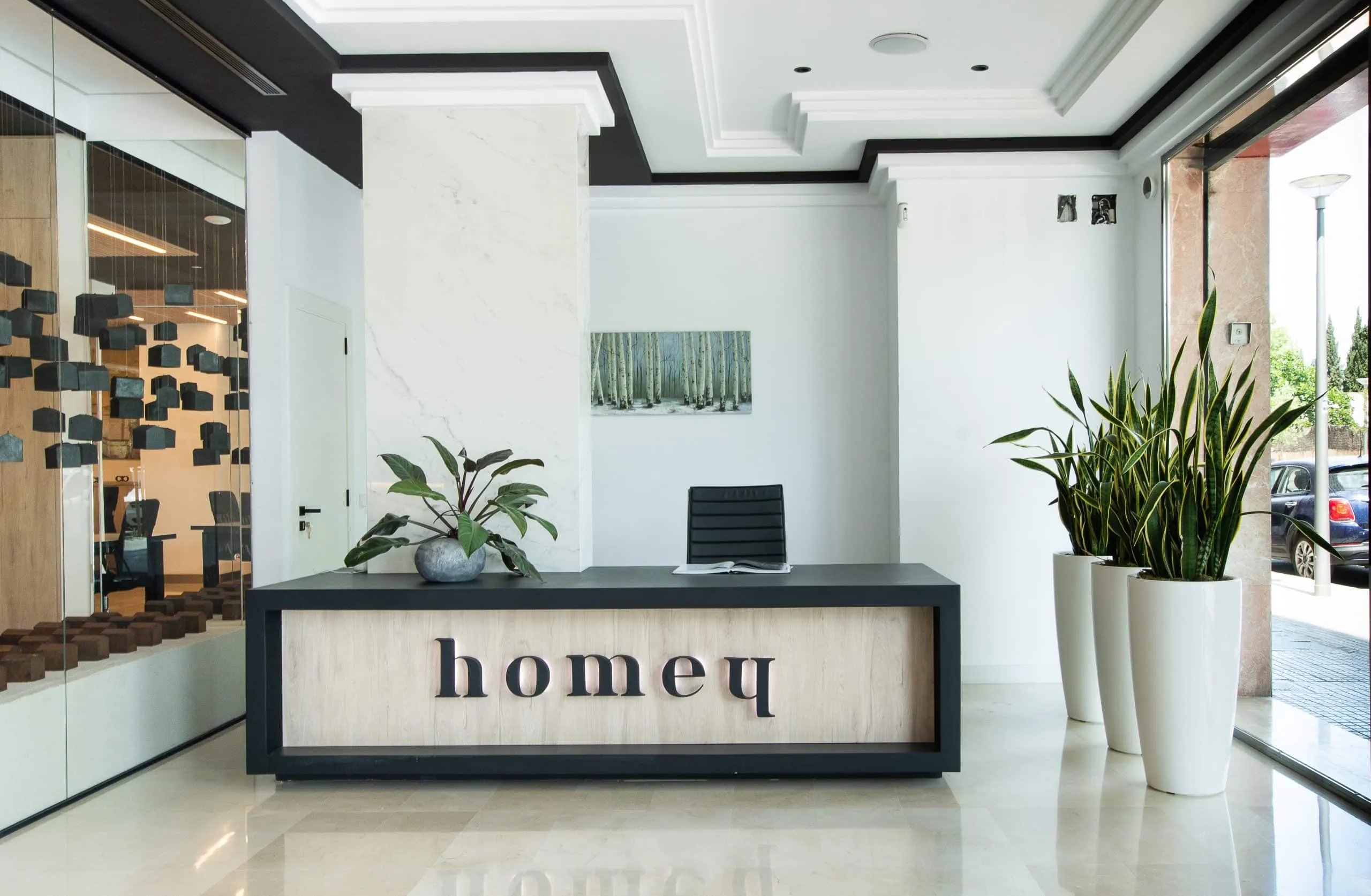 Recepción de las oficinas HOMEY en Palma de Mallorca con mostrador y plantas