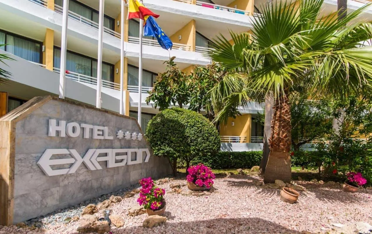 Entrada del Hotel Exagon Park con rótulo y jardín, Can Picafort