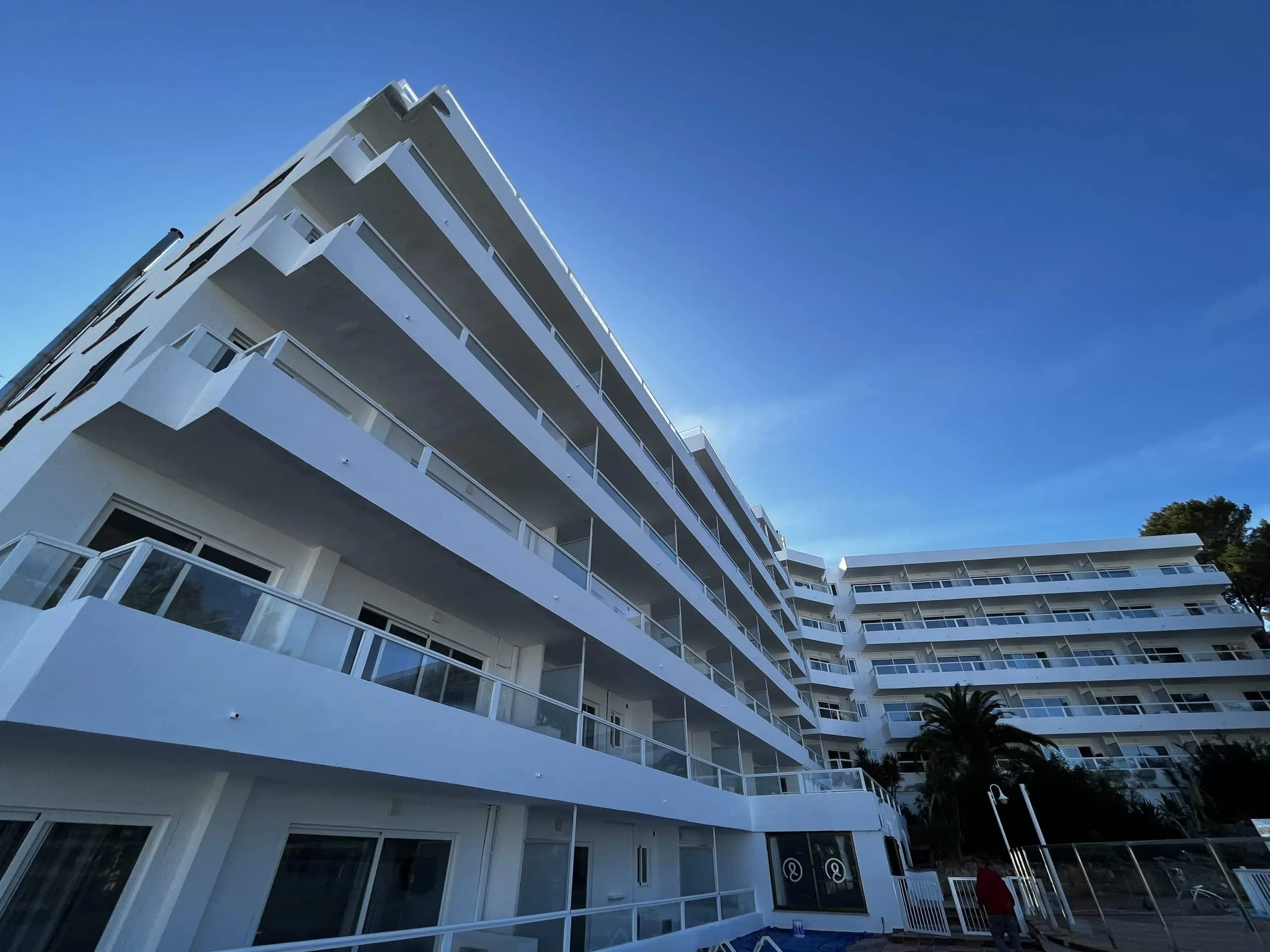 Terrazas blancas escalonadas con barandillas de vidrio del Hotel Portofino, Santa Ponça