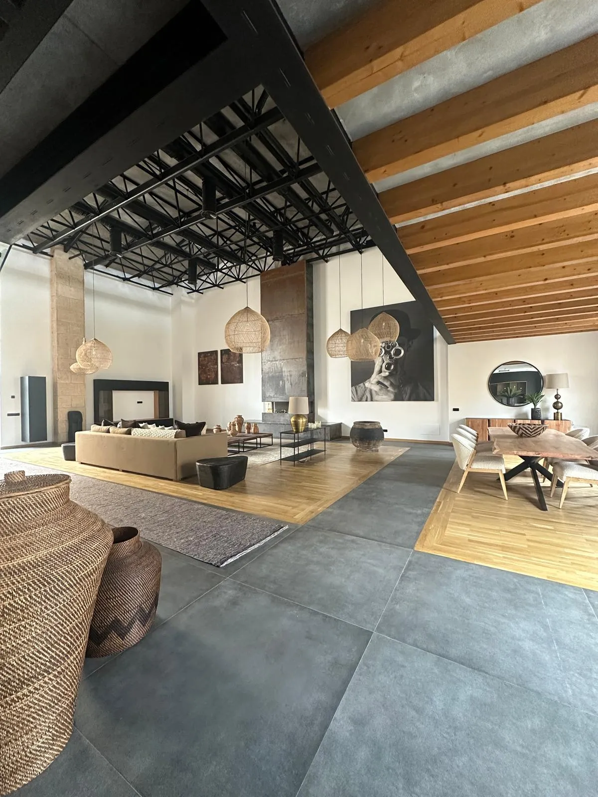 Salón y comedor de Cotoner con vigas de madera inclinadas y suelo combinado de baldosa y parquet