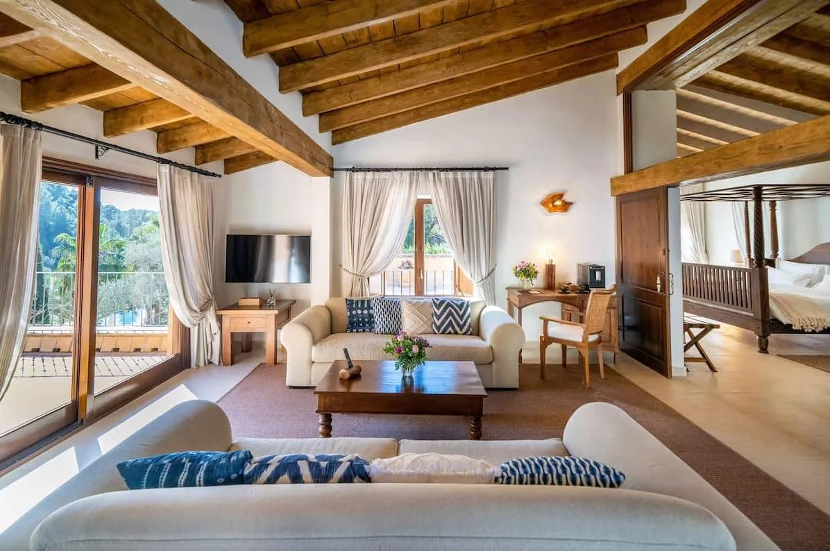 Salón de una suite en el hotel Es Ratxó con vigas de madera vistas