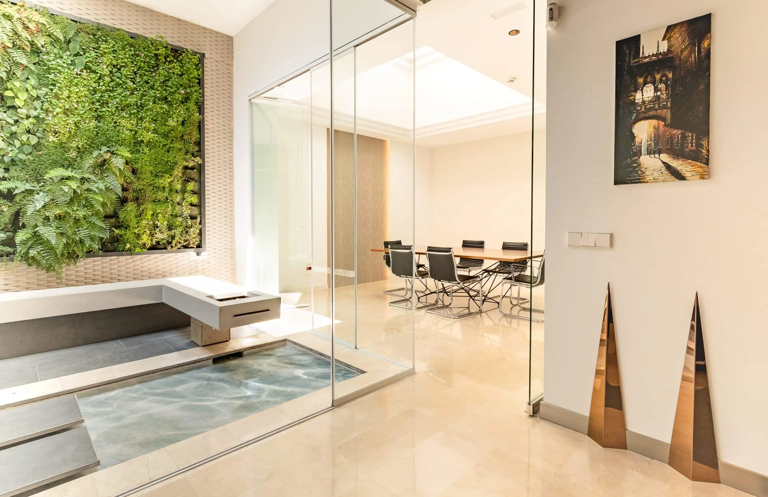 Patio interior con jardín vertical y banqueta de hormigón visto desde la oficina HOMEY, Palma