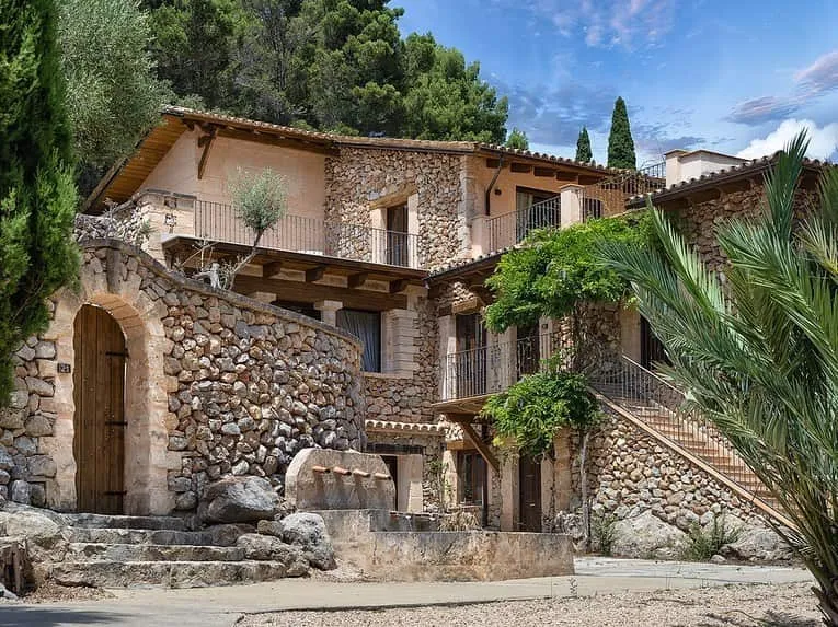 Edificio de piedra con escalera exterior en el hotel Es Ratxó, Puigpunyent