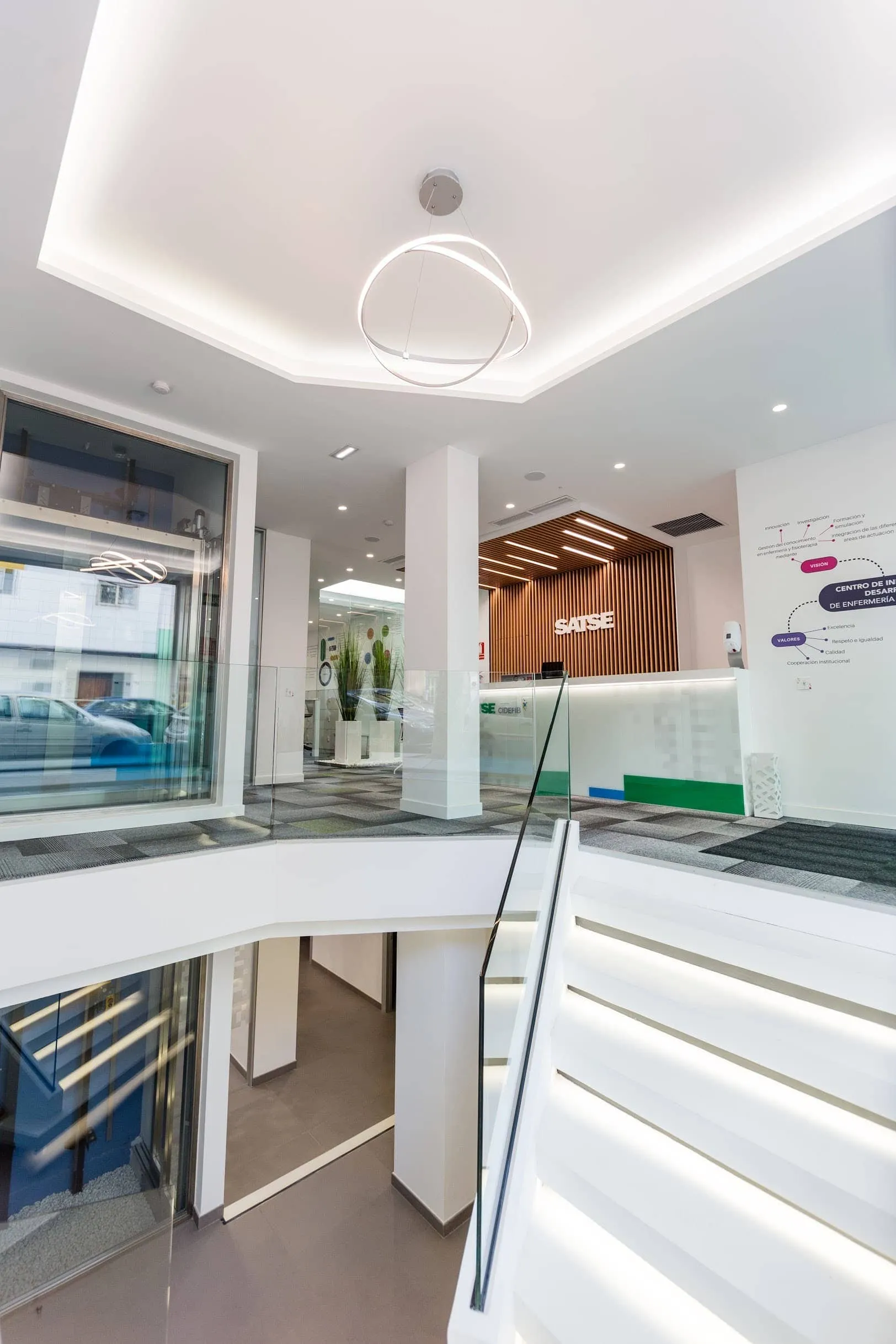 Doble altura de la oficina SATSE con aro luminoso, escalera y barandilla de vidrio, Palma