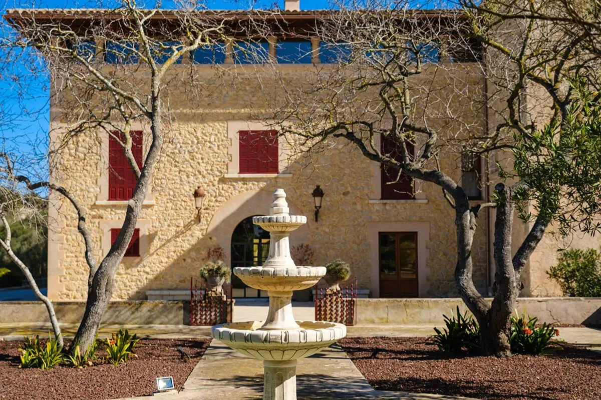 Patio de entrada del hotel Finca Sa Bastida con fuente y fachada de piedra, Sant Joan