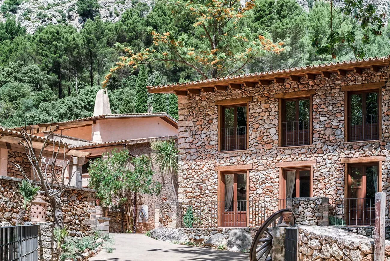 Edificio de piedra con balcones de madera del hotel Es Ratxó en Mallorca