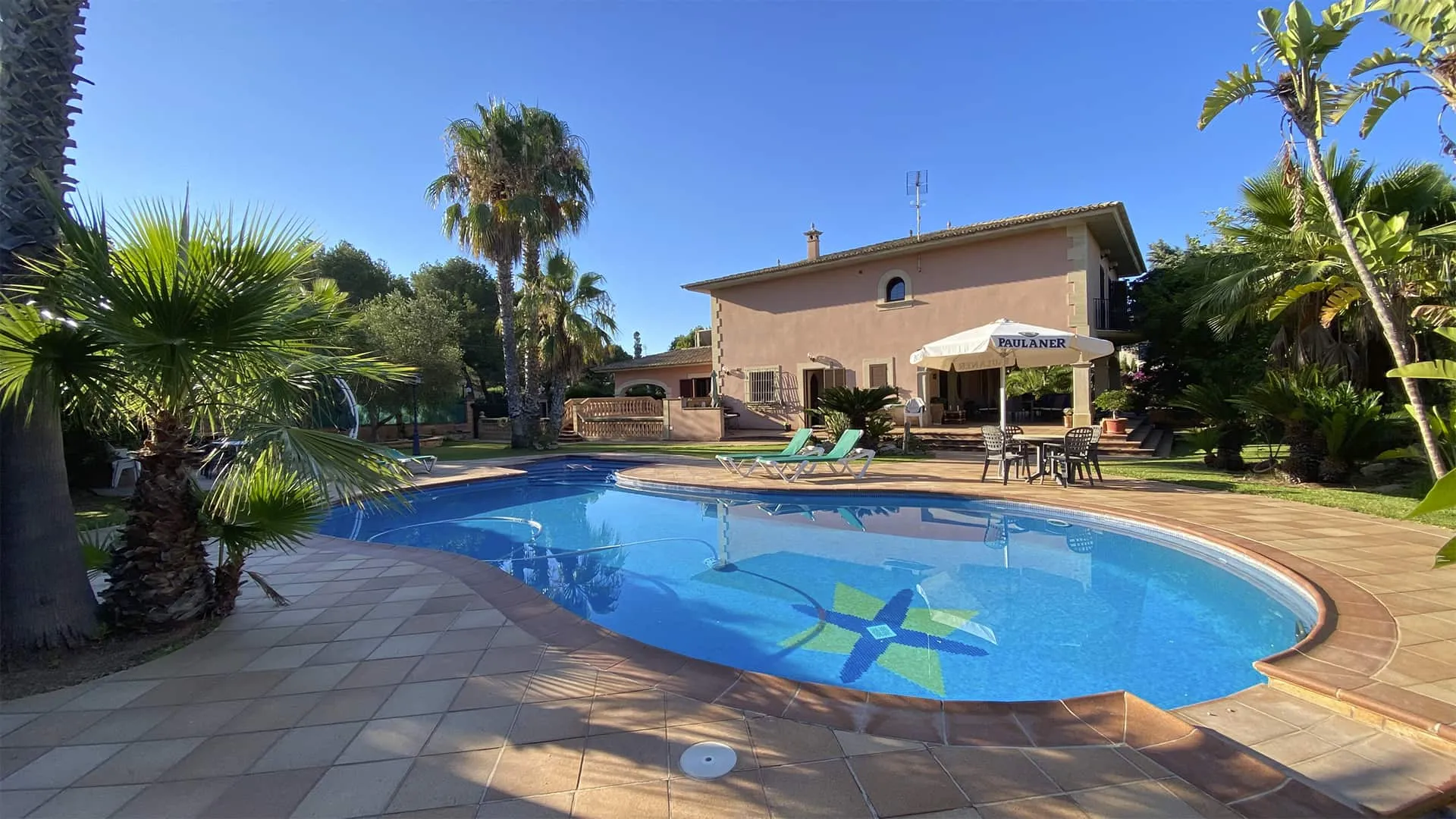 Piscina de forma orgánica con la vivienda Xiela al fondo, en Bunyola, Mallorca