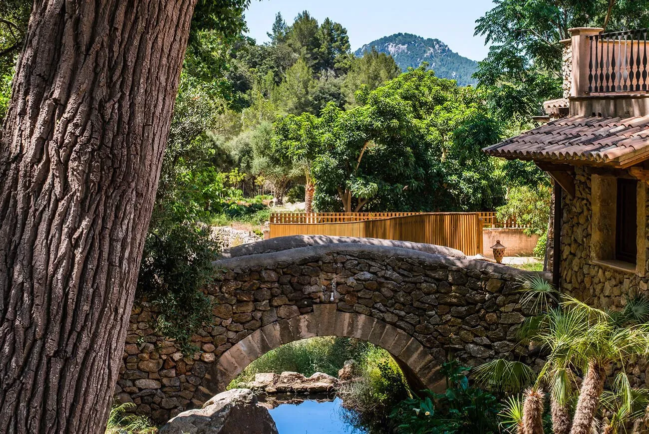 Puente de piedra sobre un arroyo en el hotel Es Ratxó, Puigpunyent