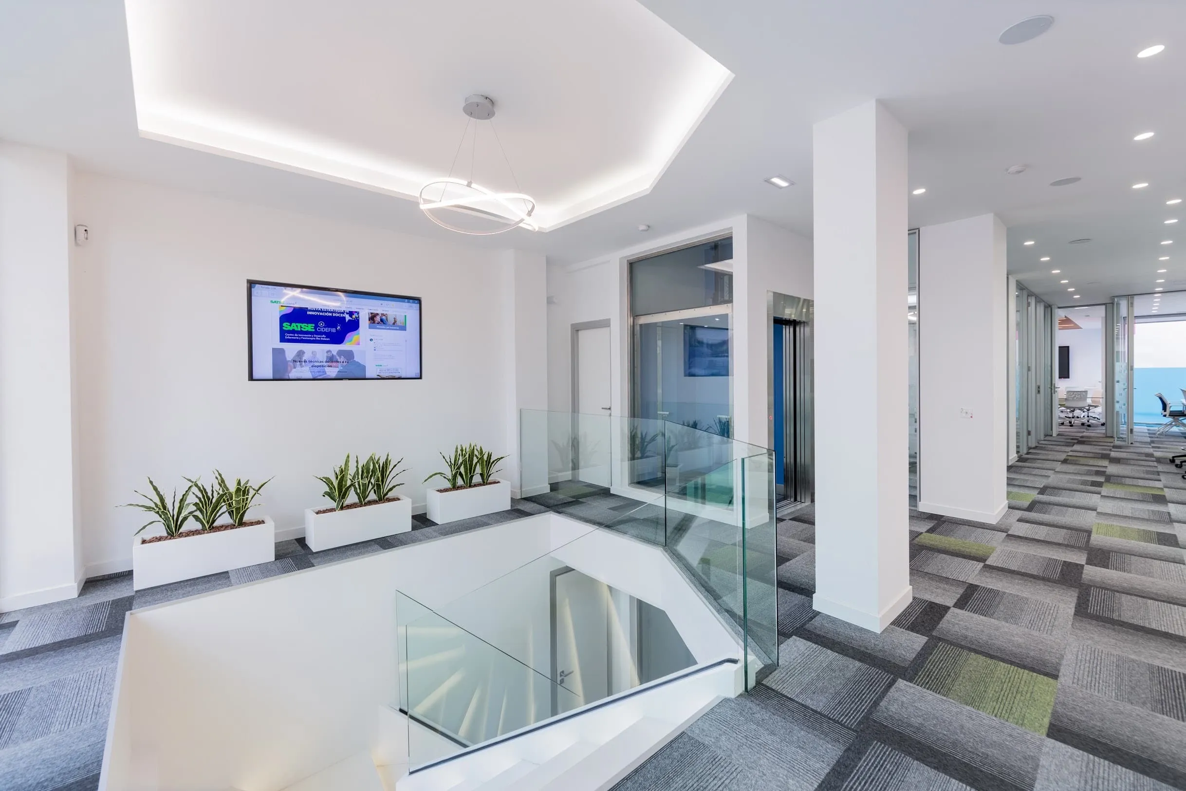 Zona de planta con jardineras y vacío de la escalera en la oficina SATSE, Palma de Mallorca