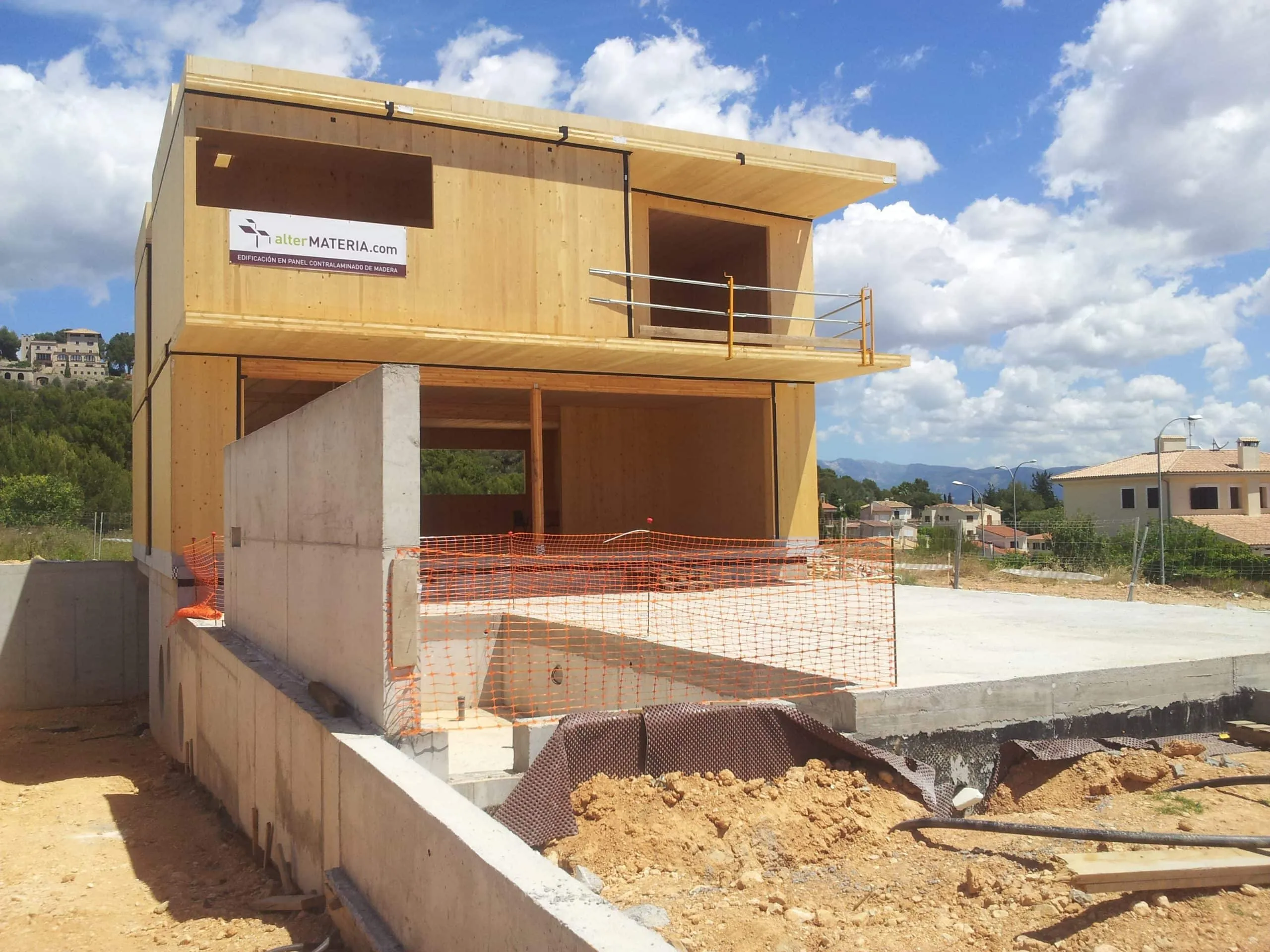Obra de ADG con estructura de madera de dos plantas y muro de hormigón
