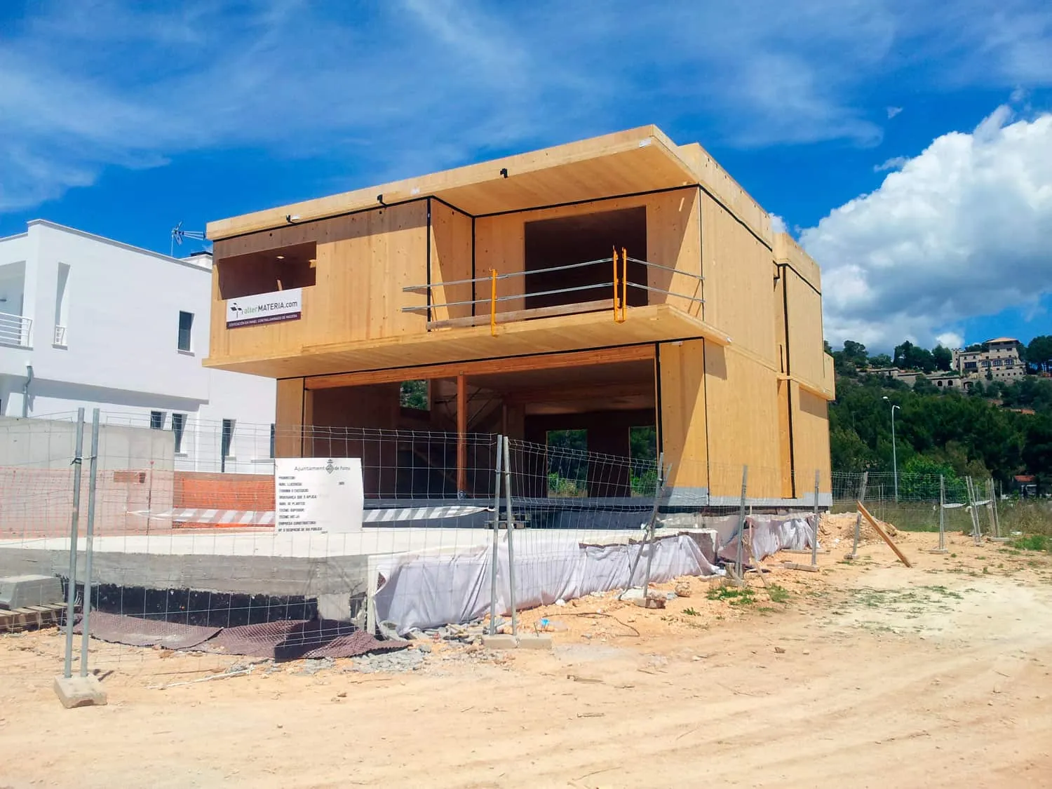 Estructura de madera de la vivienda ADG con la planta superior terminada y vallado