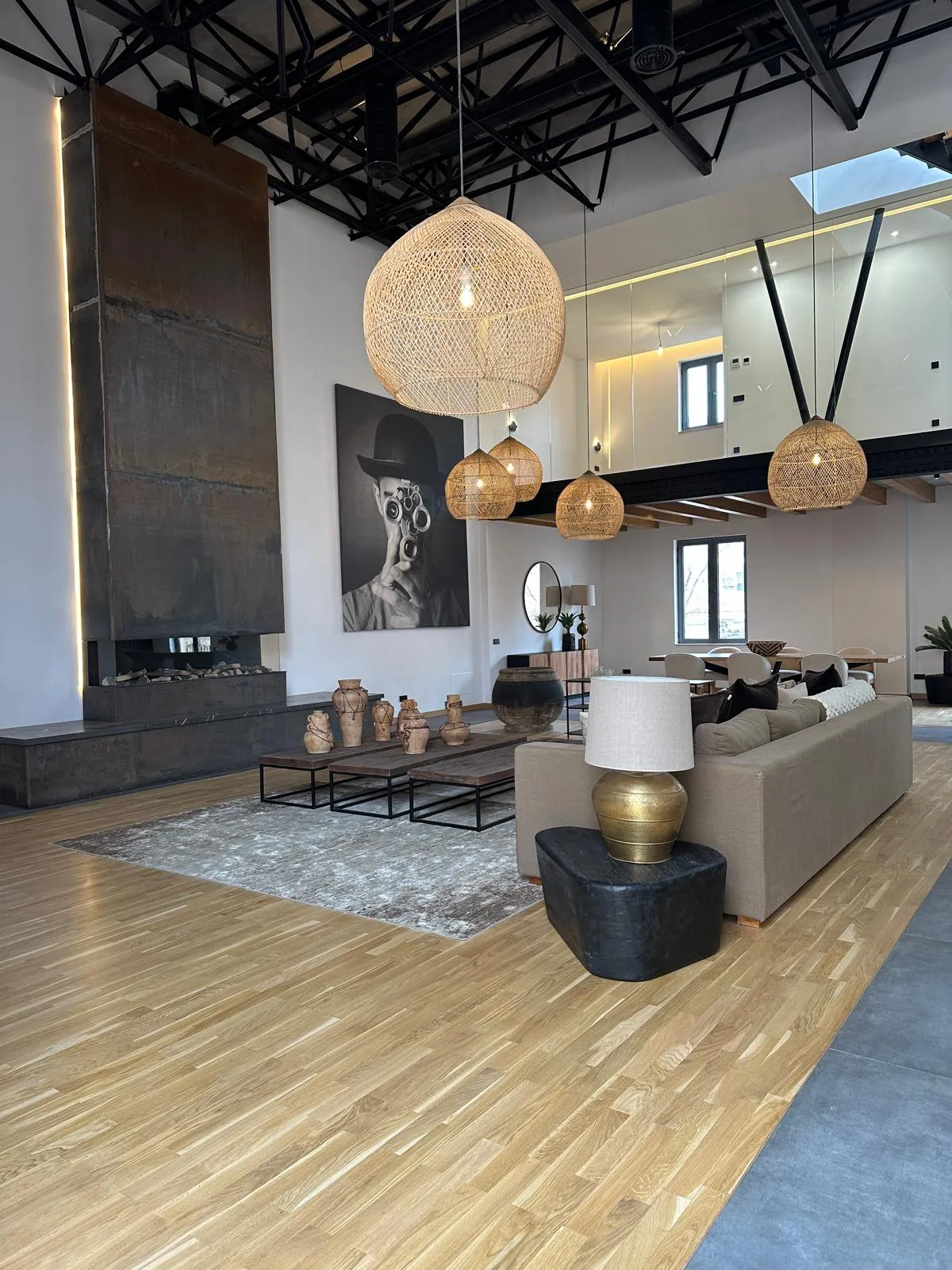 Salón de la vivienda Cotoner con chimenea metálica, estructura negra vista y suelo de parquet