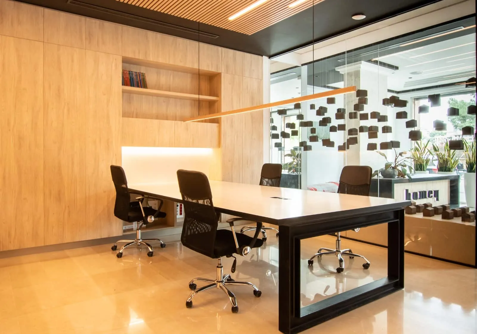 Mesa de reuniones de madera con estructura negra y sillas en la oficina HOMEY, Palma