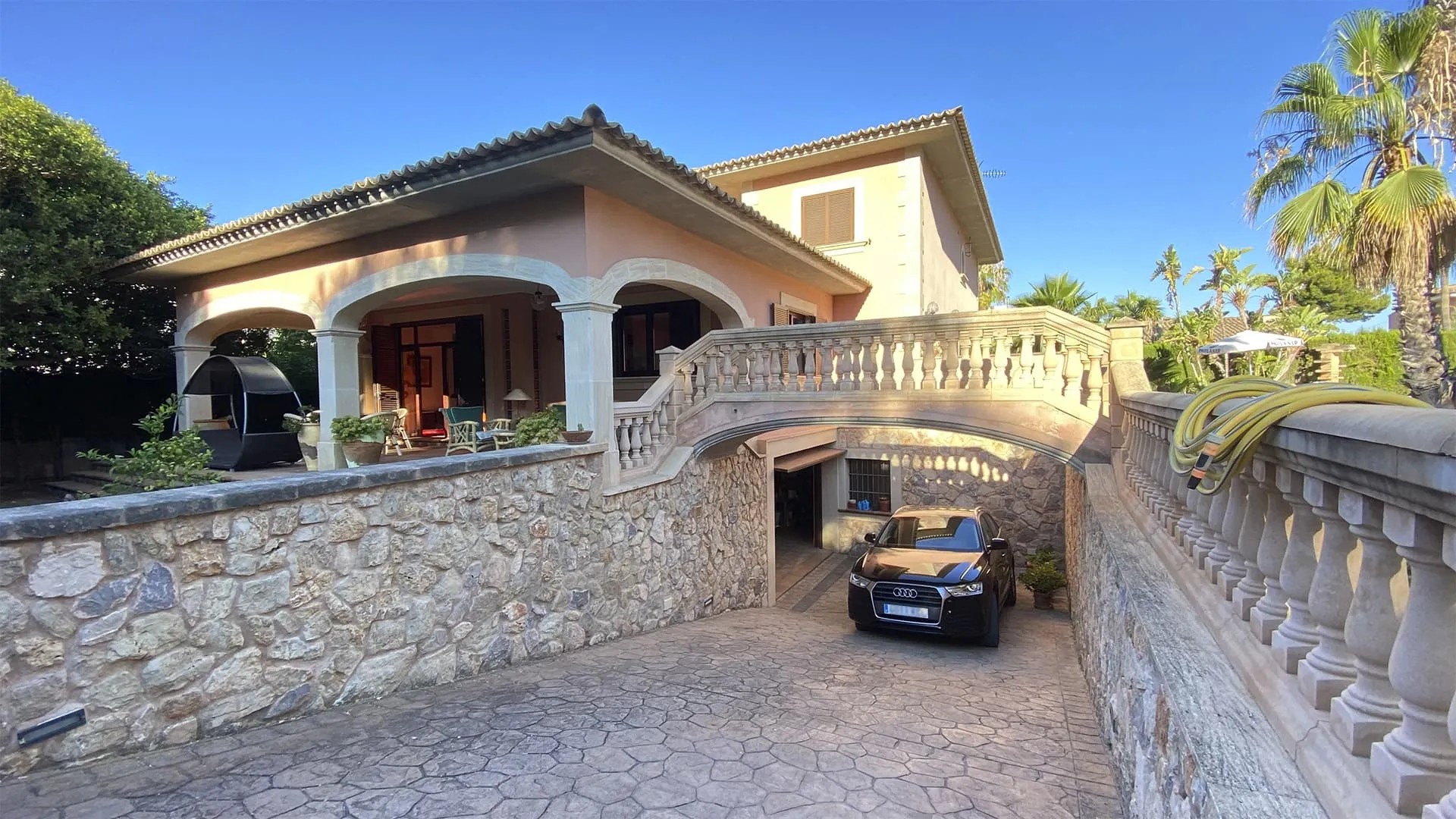 Acceso rodado cubierto bajo balaustrada y muro de piedra en la vivienda Xiela, Bunyola