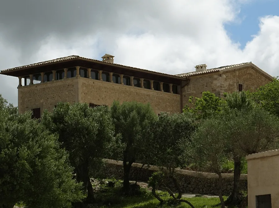 Edificio principal de la finca Sa Bastida visto entre olivos, en Sant Joan, Mallorca