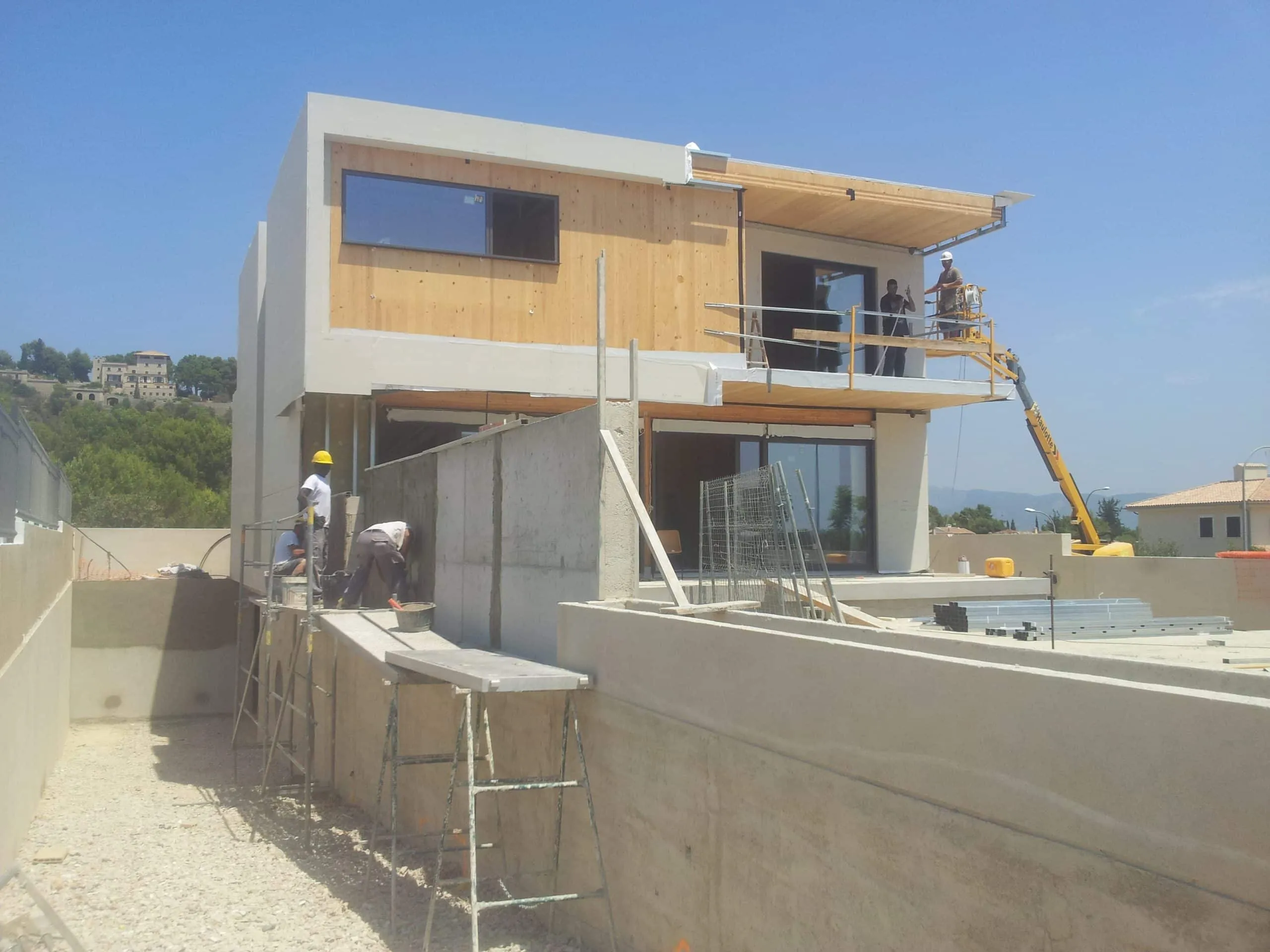 Terraza y fachada trasera de ADG en obra con andamio y piscina vacía