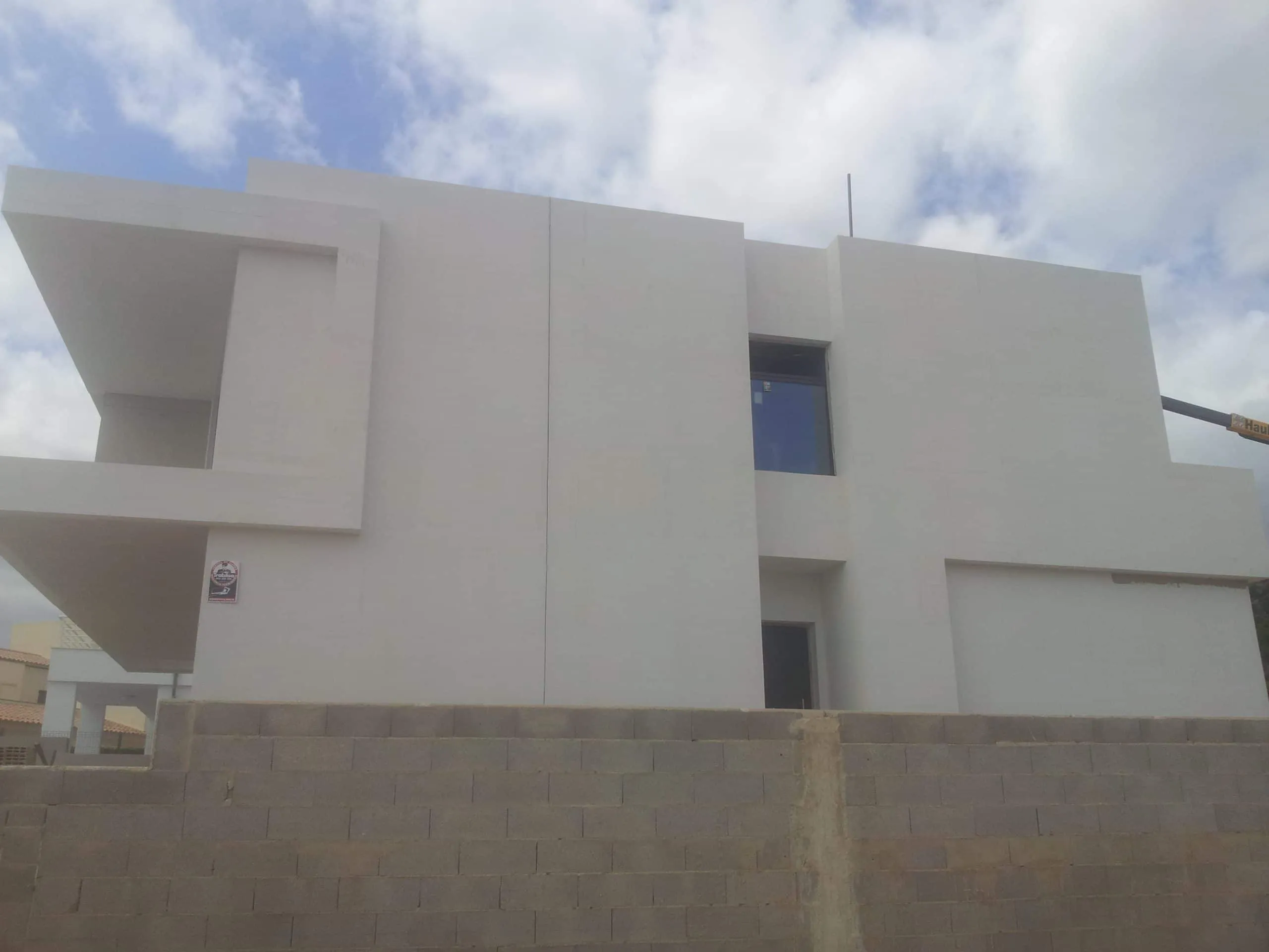Fachada lateral de ADG con volumen blanco y terraza volada