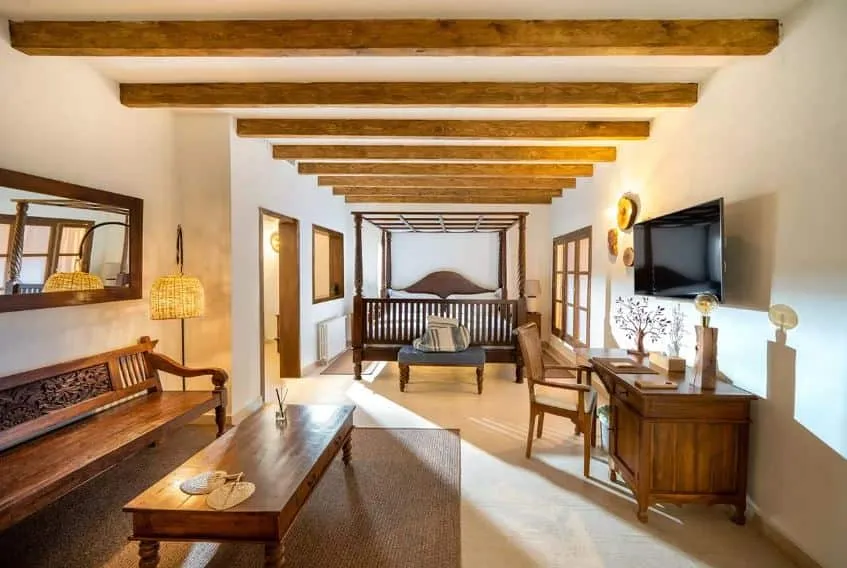 Habitación del hotel Es Ratxó con vigas de madera y cama con dosel